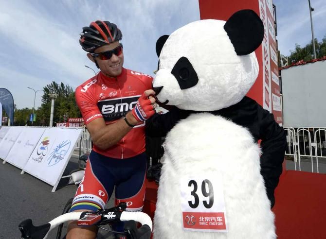 Thor Hushovd (BMC) exchanges greetings with a man dressed as a panda at the Tour of Beijing.
