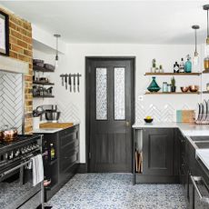 Black and white kitchen with facebrick chimney and gas stove
