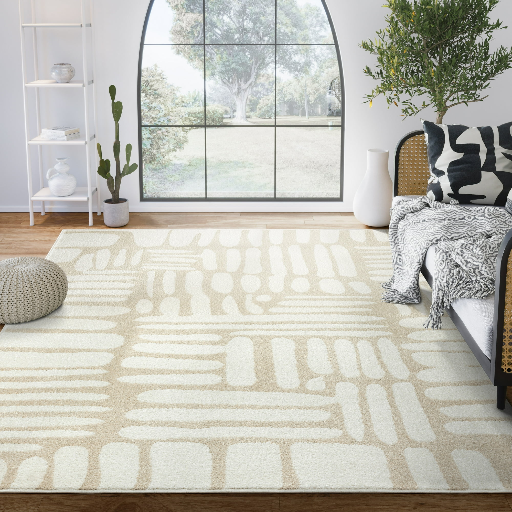 A beige and white patterned area rug in a bright living room