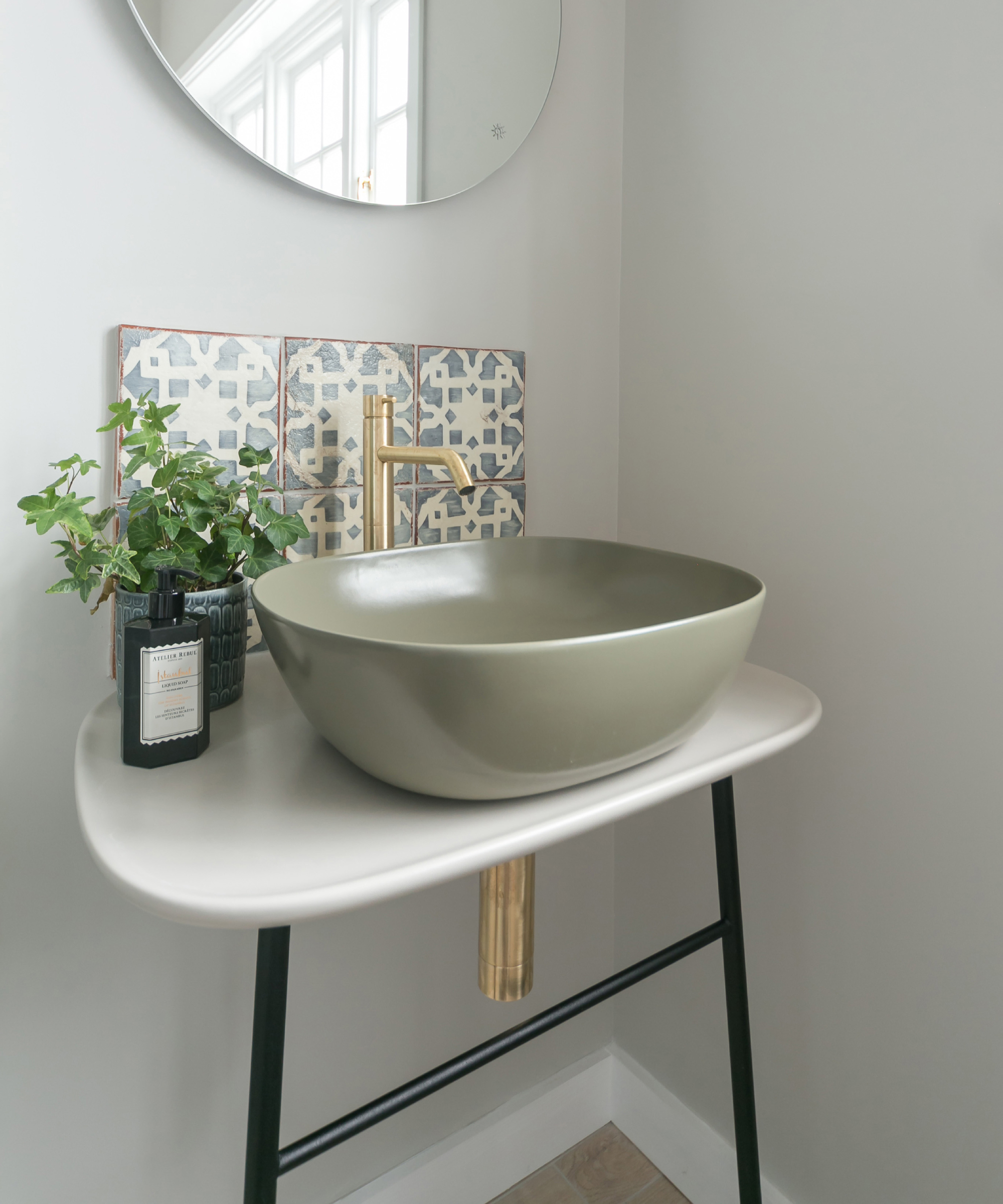 grey bathroom walls with simple vanity, grey green sink and grey and white tiled splashback