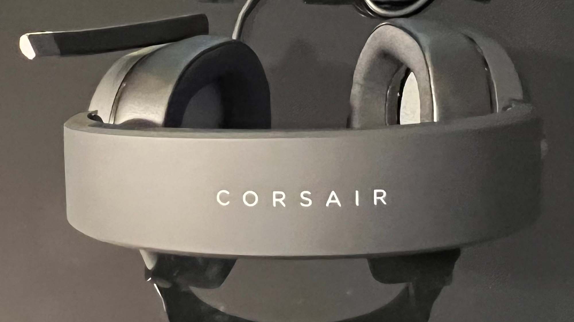 Um Corsair HS65 Surround em uma mesa preta reflexiva