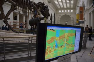 visitors to the field museum in chicago watch a model of t. rex being created