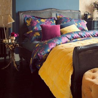 bedroom with yellow duvet and wooden floor and bedside lamp