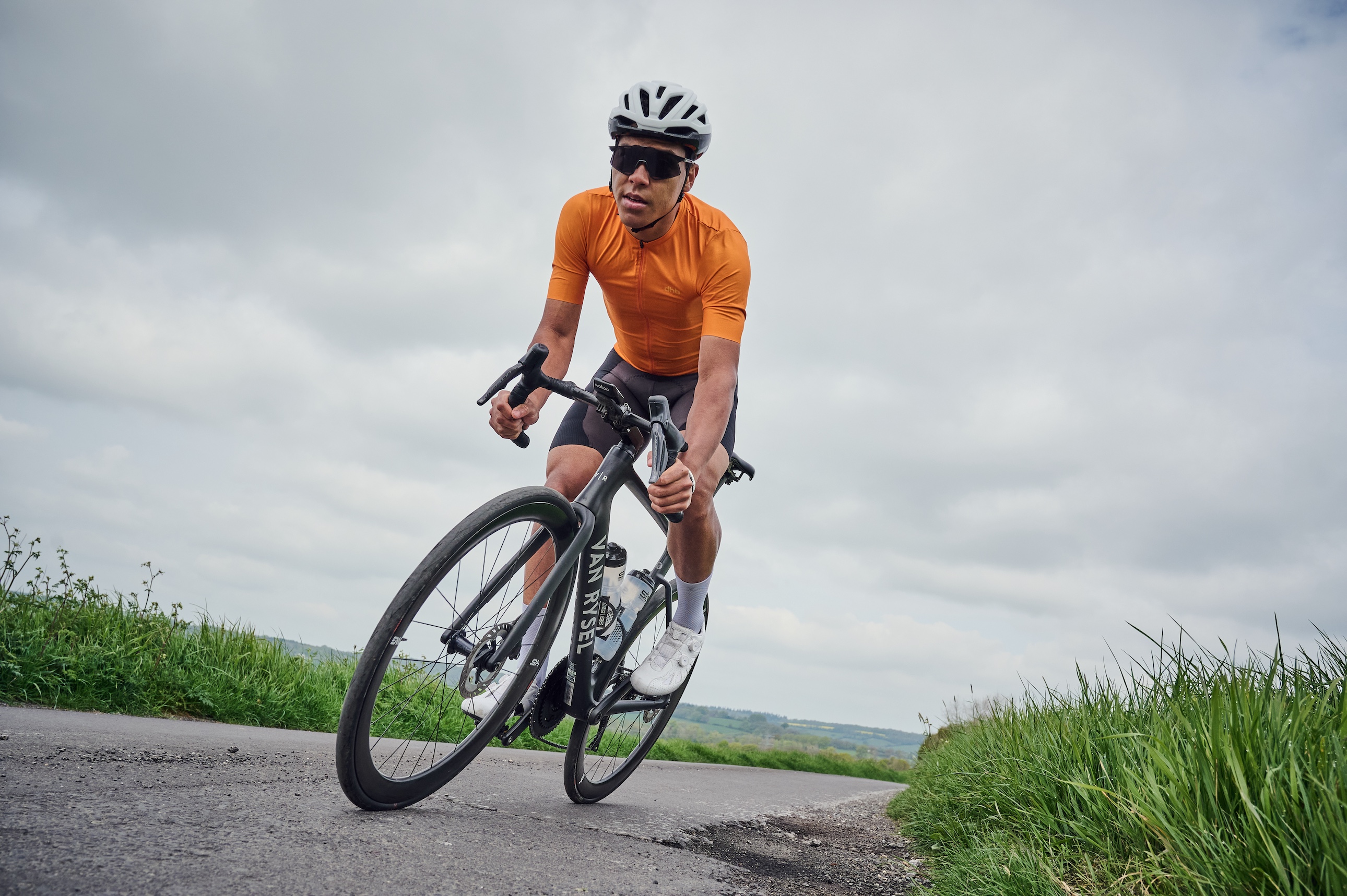 Male rider in orange jersey on a country road