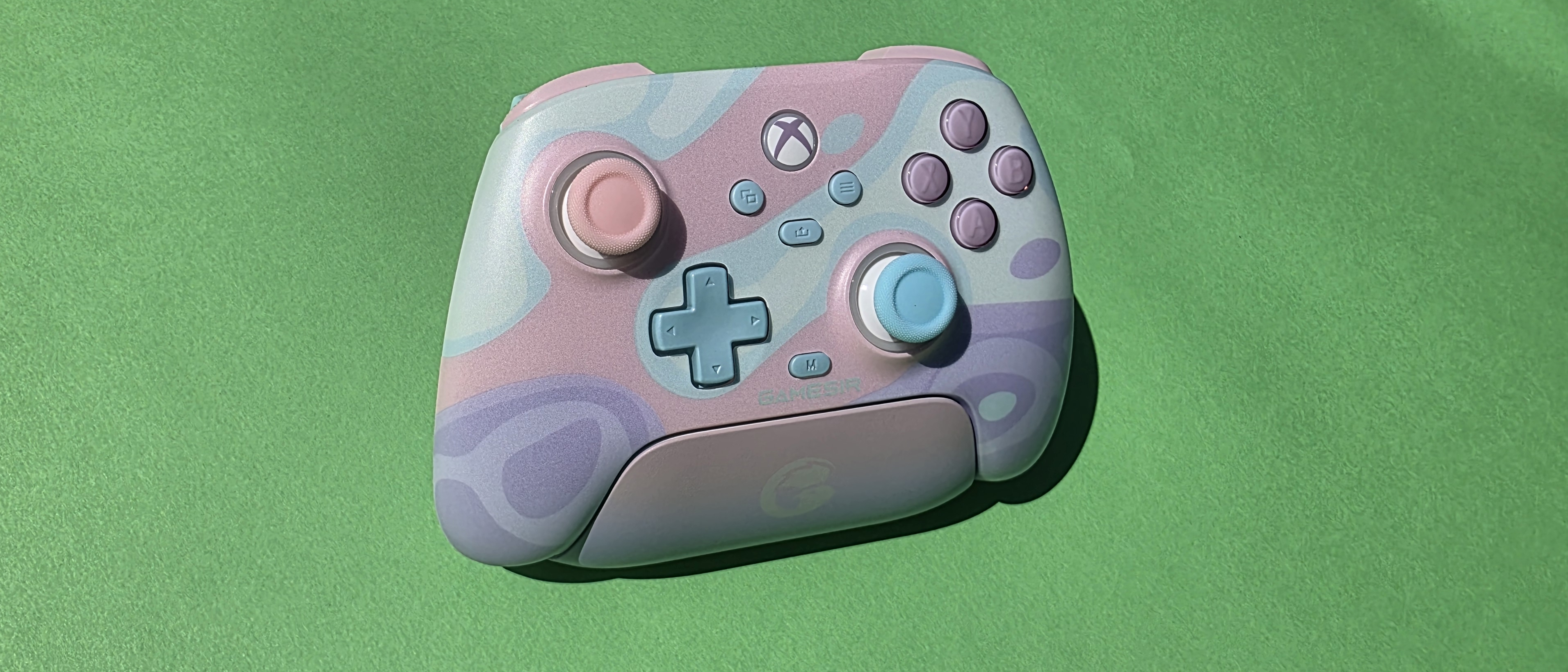 Pastel coloured gaming controller on a green background