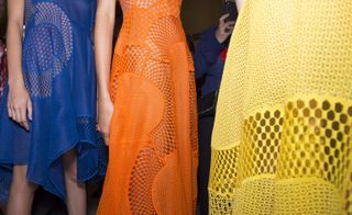 Models wearing orange yellow and blue outfit