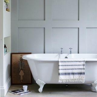 bathroom with bathtub grey wall and wooden flooring