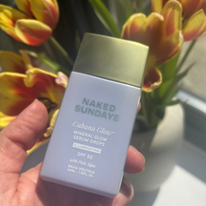 a hand holding Naked Sundays Mineral glow spf serum