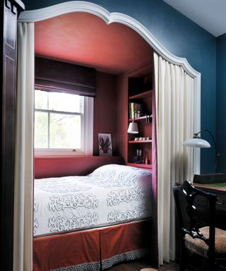 A nook bed with a red interior and a blue exterior and a cream curtain