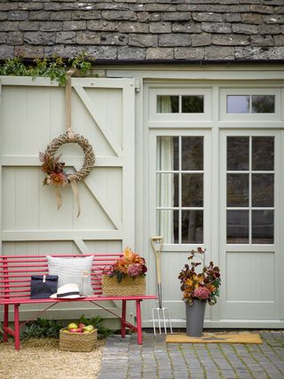 fall front door with pink bench, fall wreath