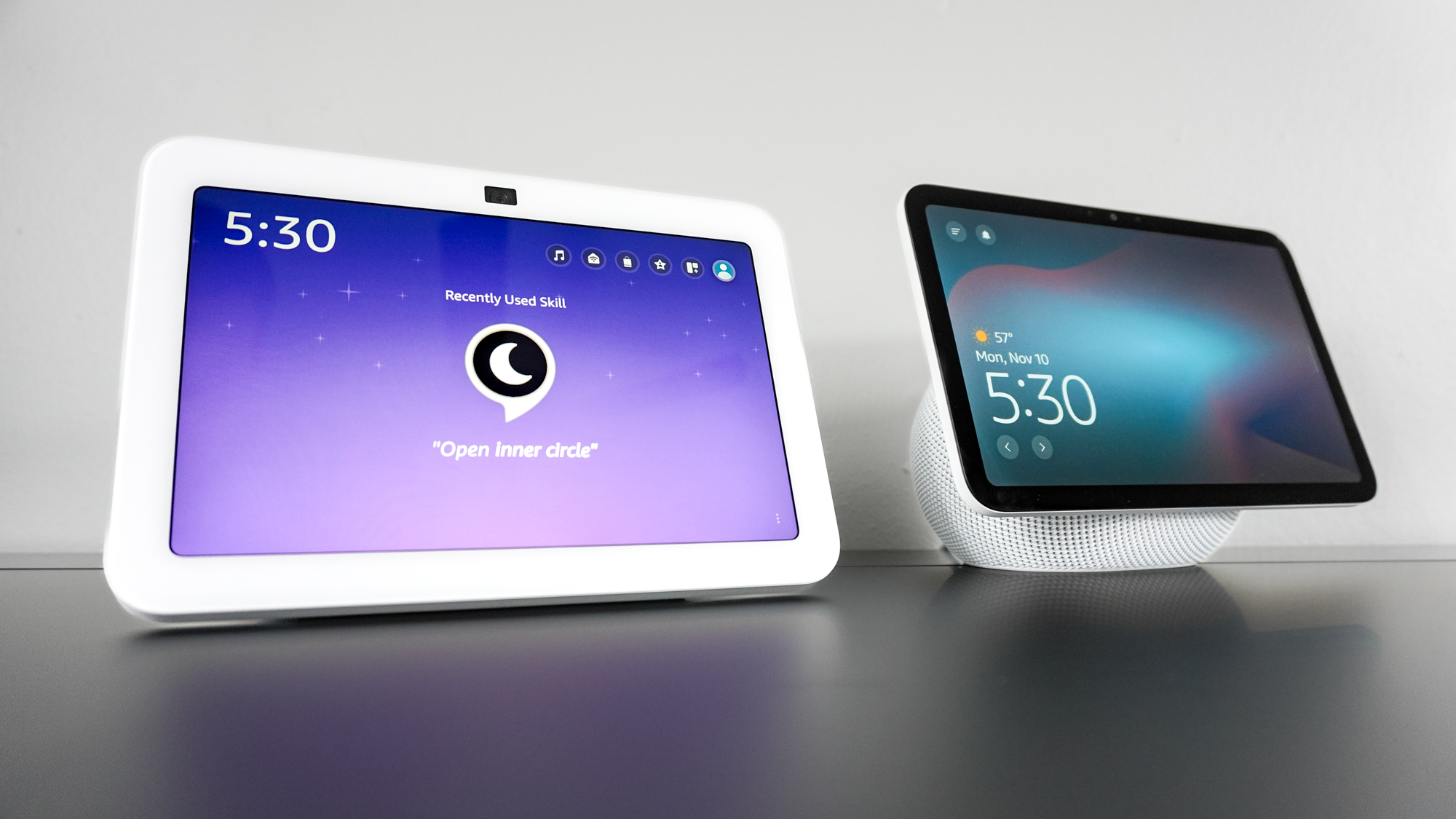 An angled shot of the Echo Show 8 (4th Gen) and Echo Show 8 (3rd Gen) on a desk showing off the differences in bezel size between the two