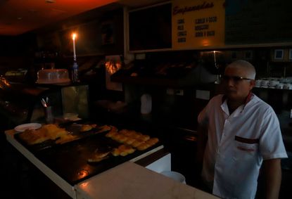 A man tries to work in the dark at a bakery in Argentina.