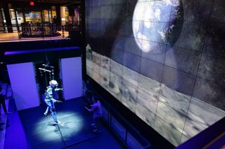 Hanging from a "gravity offload rig" at the Samsung 837 center in New York City, NASA astronaut Mike Massimino takes a virtual trip to the moon on July 17, 2018.