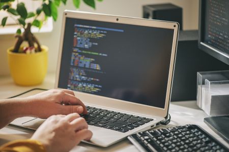 Person works on code on a computer screen.