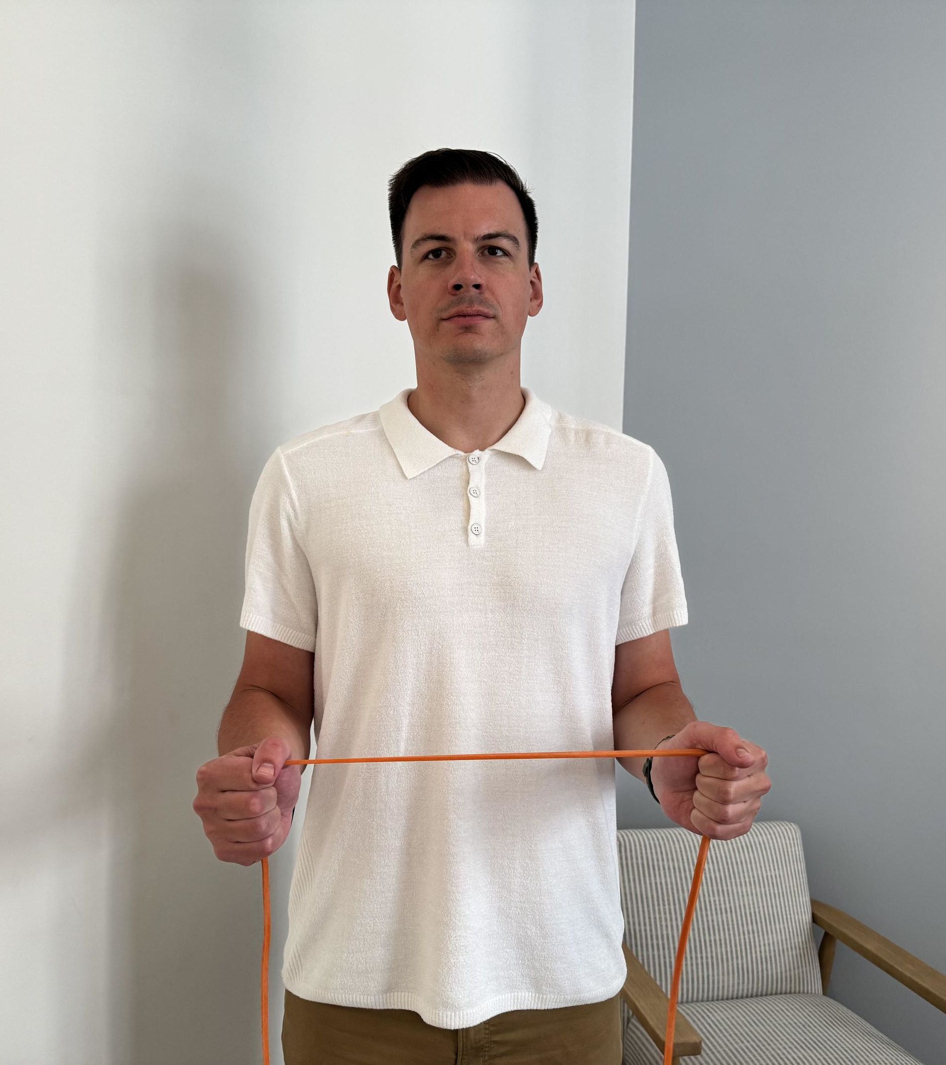 A man holding a thin orange resistance band