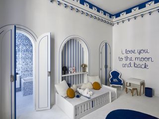 blue and white boys bedroom with blue and white stripes, white carpet, ensuite in the background, blue edging along the top