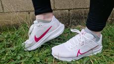 Fitness writer Lou Mudge models the bright white Nike Pegasus 40 shoes on a patch of grass.