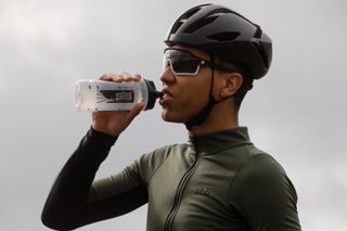 Image shows a cyclist consuming sugar on a bike ride