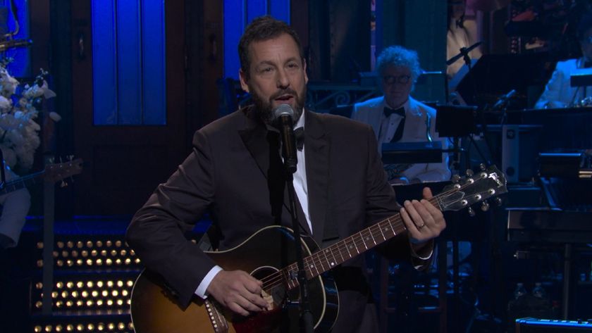 Adam Sandler playing a song with his guitar at SNL50: The Anniversary Special.