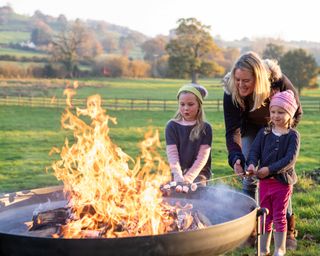 girls toasting marshmallows around firepitsUK fire pit