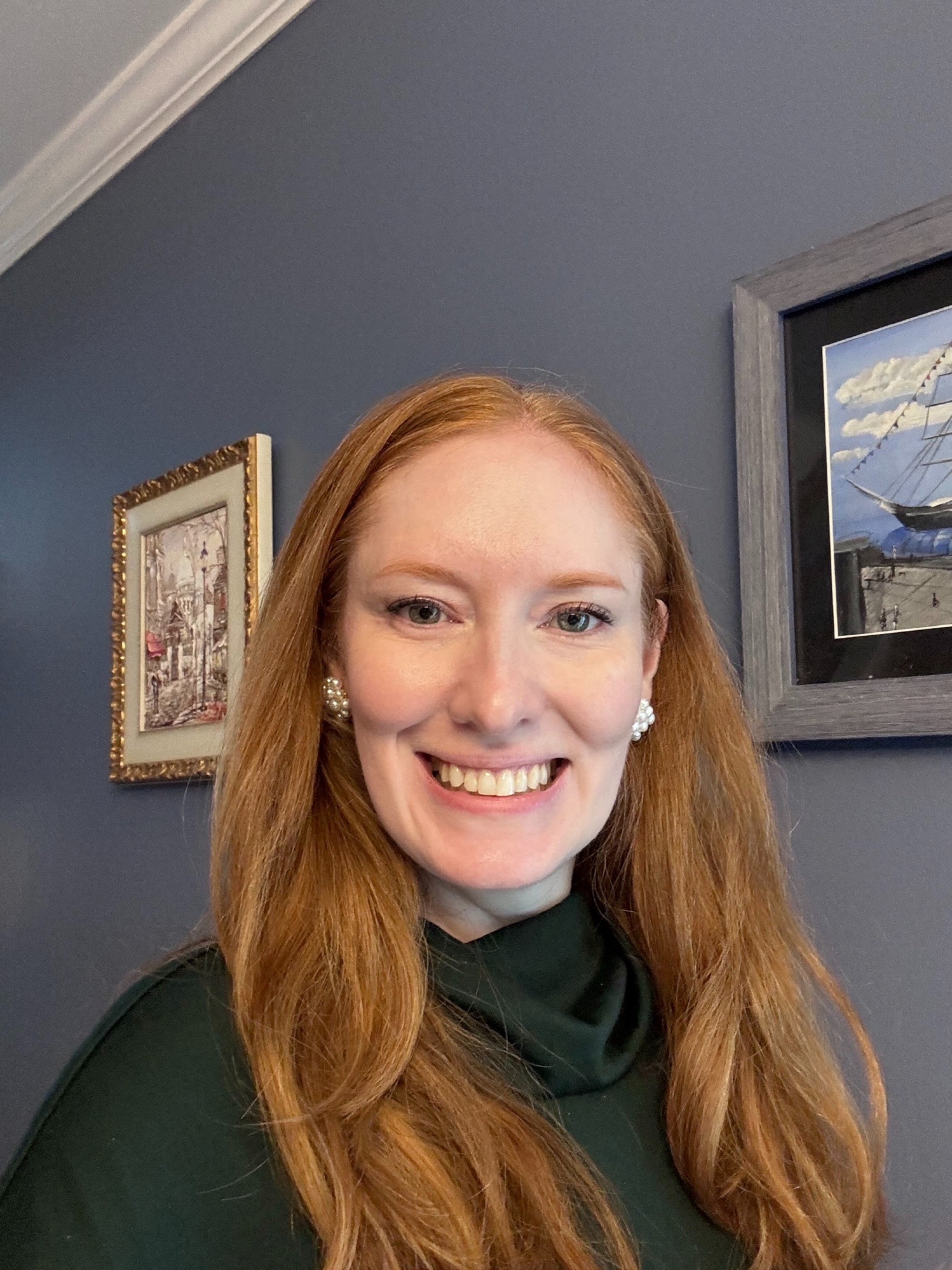 Kristin Contino wearing a green shirt standing in front of a blue wall