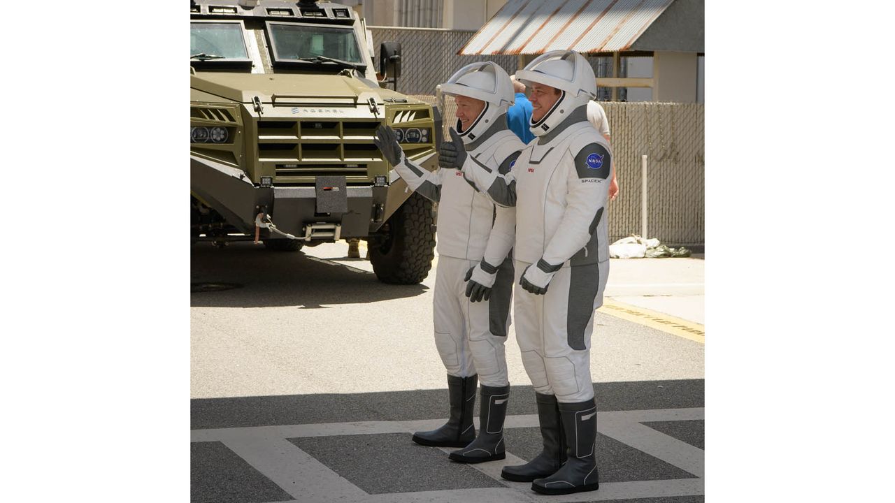 NASA astronauts Bob Behnken and Doug Hurley walk out of NASA's Astronaut Crew Quarters and take a Tesla Model X to Launch Pad 39A during a dry-run test of their SpaceX Crew Dragon Demo-2 flight on May 23, 2020 at the Kennedy Space Center in Florida.