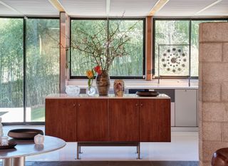 Modernist house kitchen with wood furniture, stone walls, terrazzo floor and large windows