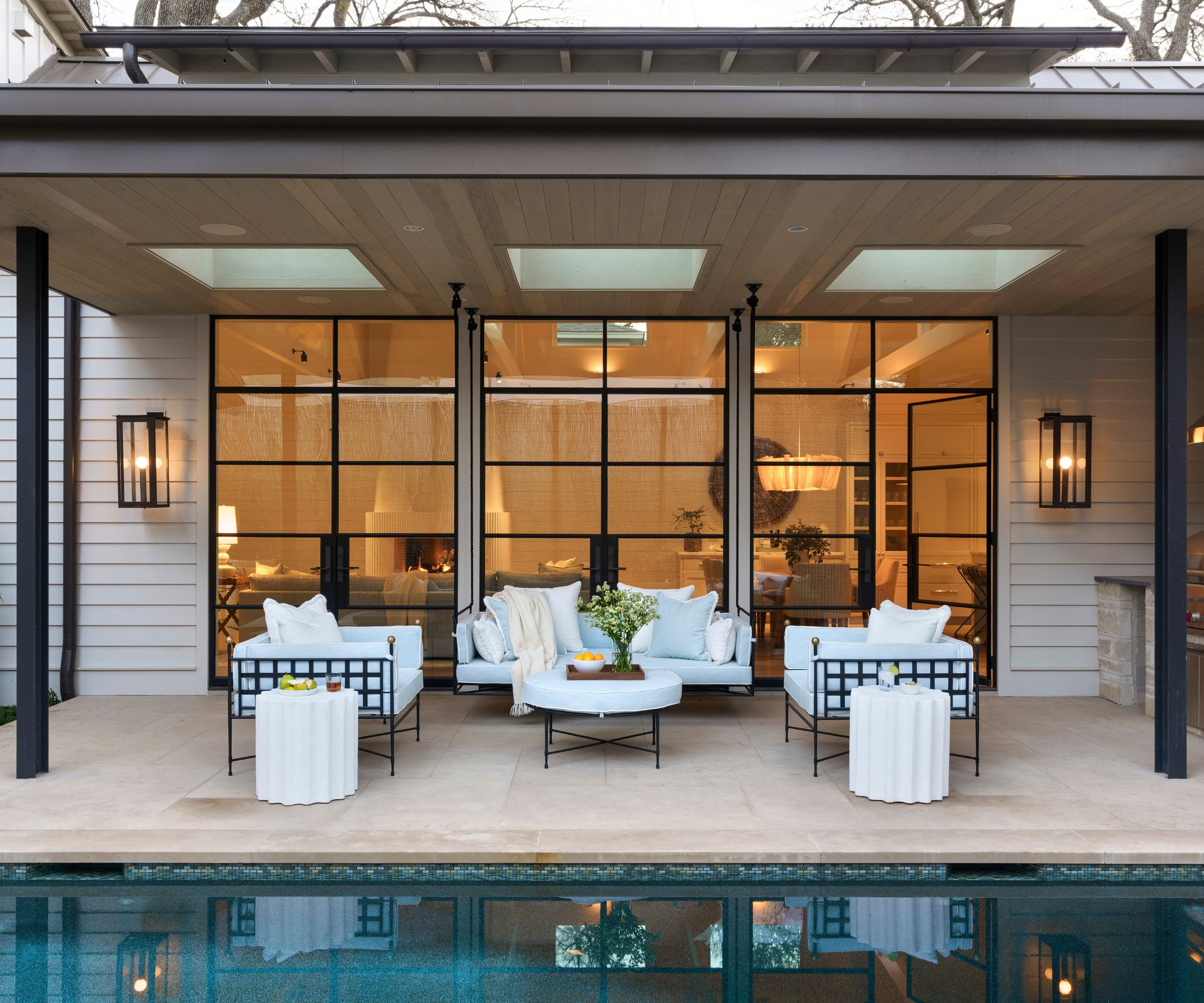 Outdoor living area in a covered porch overlooking a pool
