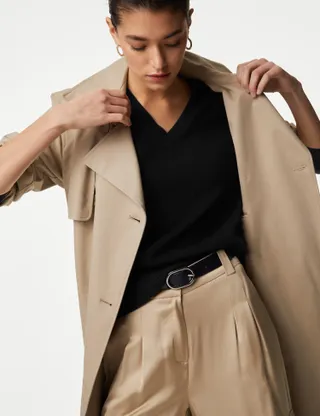 A model wears a beige M&S trench coat with wide-leg trousers