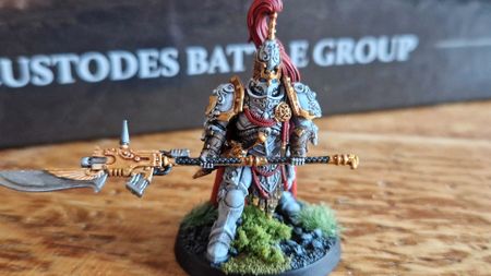 A painted Legio Custodes miniature on a wooden surface