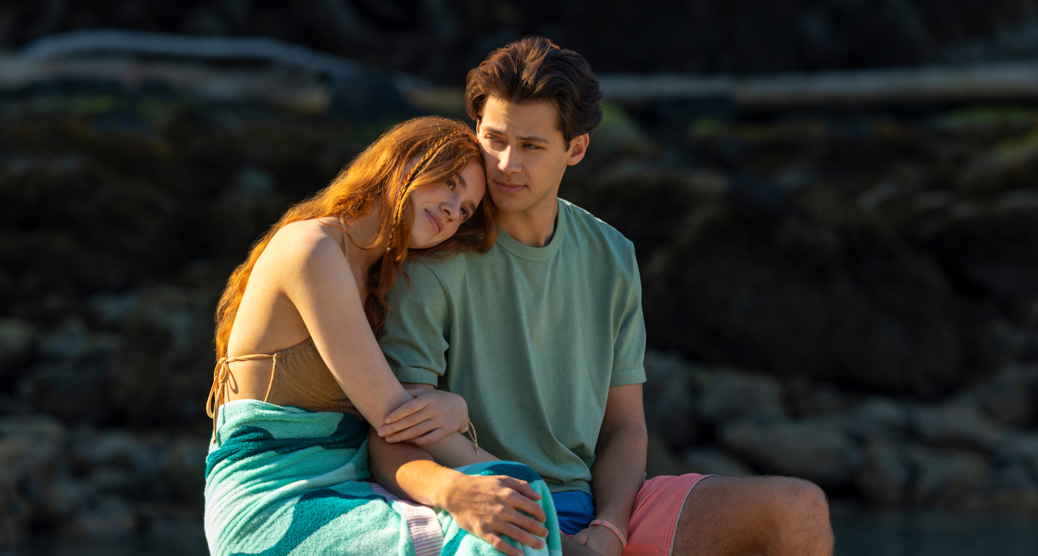 sadie soverall as percy and matt cornett as sam sitting on a dock together in every year after