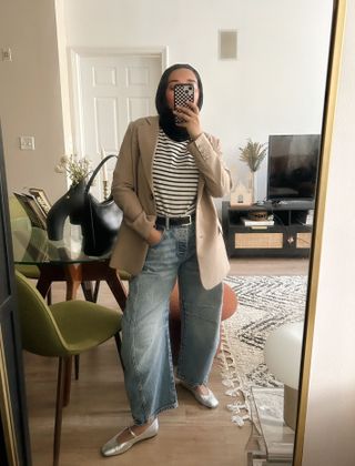 an editor wearing barrel-leg jeans