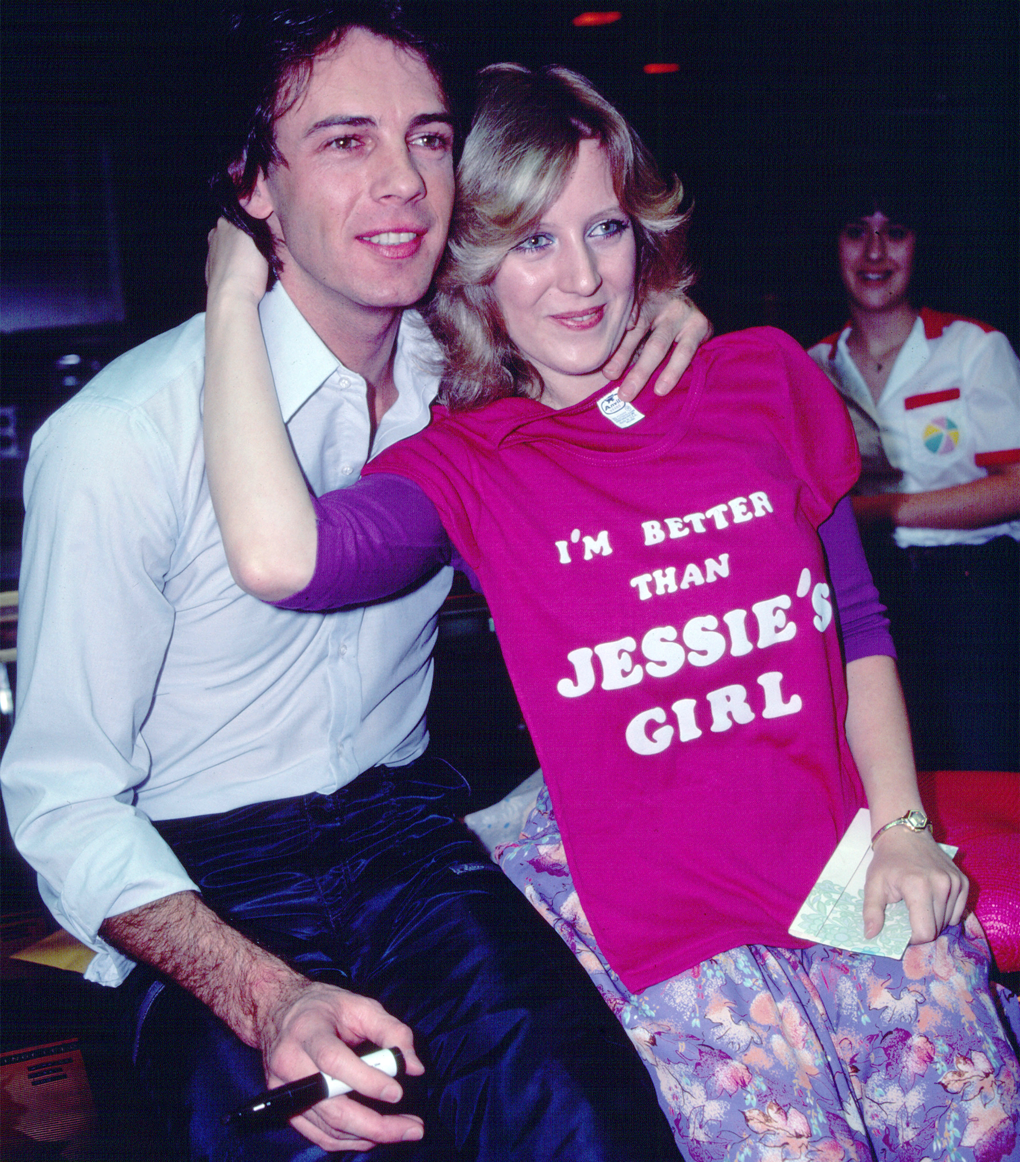 Australian-American Pop musician Rick Springfield poses with an unidentified fan during an instore appearance at the J&amp;amp;R Music store, New York, New York, June 18, 1981. He was there to promote the release of his 'Working Class Dog' album; the fan poses with a t-shirt that reads 'I'm Better Than Jessie's Girl' (referencing a song on the album).