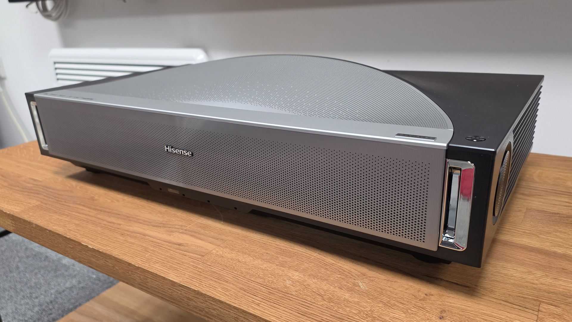 Hisense PX4 Pro UST projector on wooden AV rack