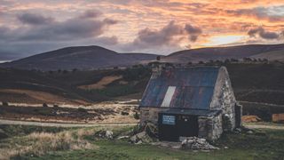 A sunrise view of Ryvoan Bothy in Scotland