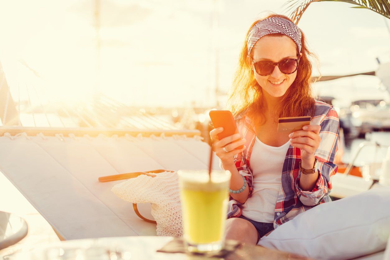 Woman in a hammock using credit card for online shopping+++++ Note for the inspector : Credit card is fake +++++