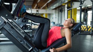 A woman using the leg press machine at the gym