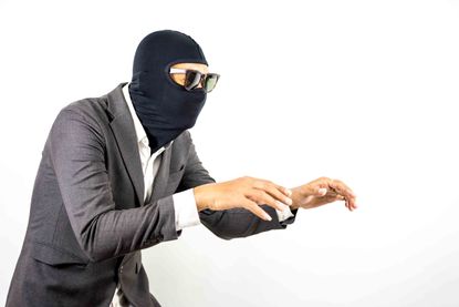 Man in a suit with a ski mask and glasses on