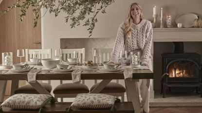 Stacey Solomon sat on cream sofa with homeware collection around her.