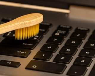 cleaning a laptop keyboard with brush