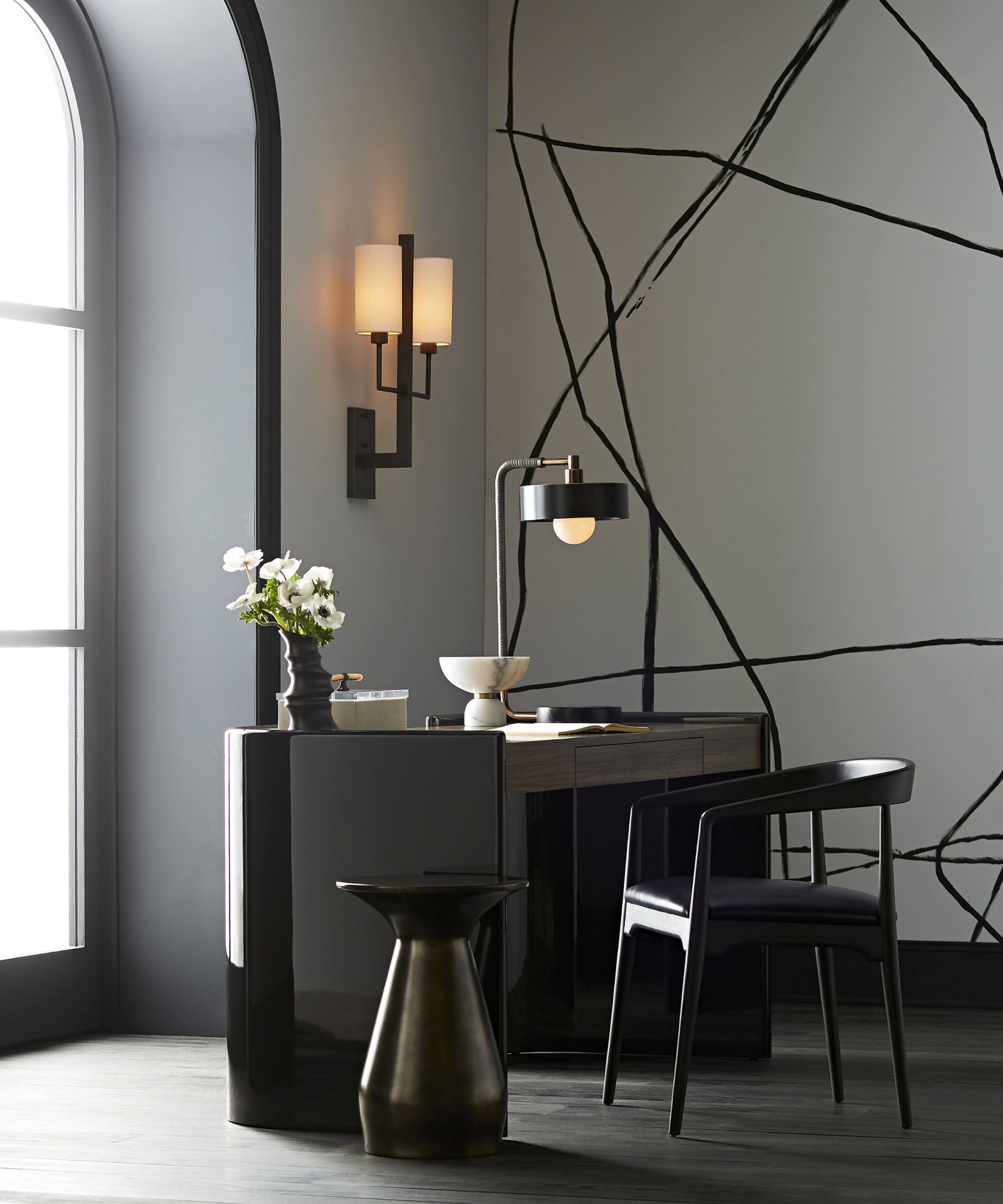 home office with black and white glass wall light, black table lamp