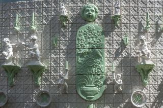 Ornaments such as ceramic mermaids and dolphin statues adorn the walls