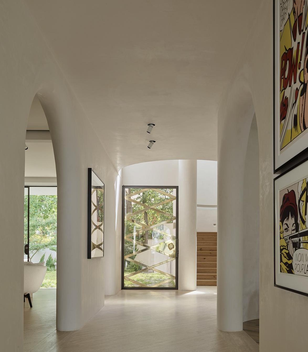 A passageway in all white with spotlights on the ceiling 