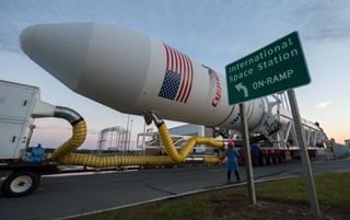 The Orbital ATK Antares rocket carrying the Cygnus cargo ship rolls out to its Pad-0A launchpad at NASA's Wallops Flight Facility on Wallops Island, Virginia for the Oct. 16, 2016 launch of more than 2 tons of NASA cargo to the International Space Station