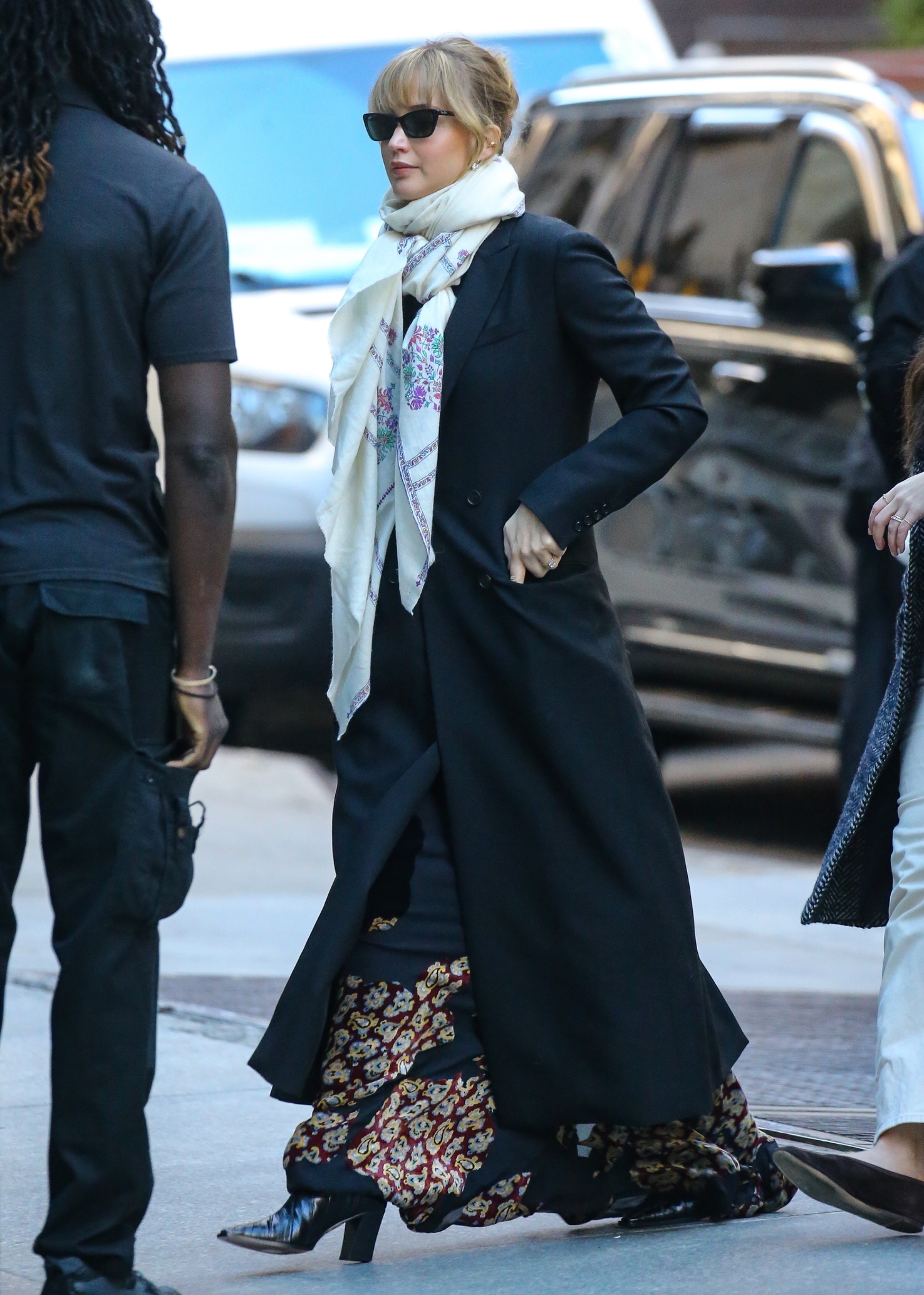 Jennifer Lawrence was spotted in New York wearing a patterned black maxi dress, a black coat, a white scarf, and patent leather boots