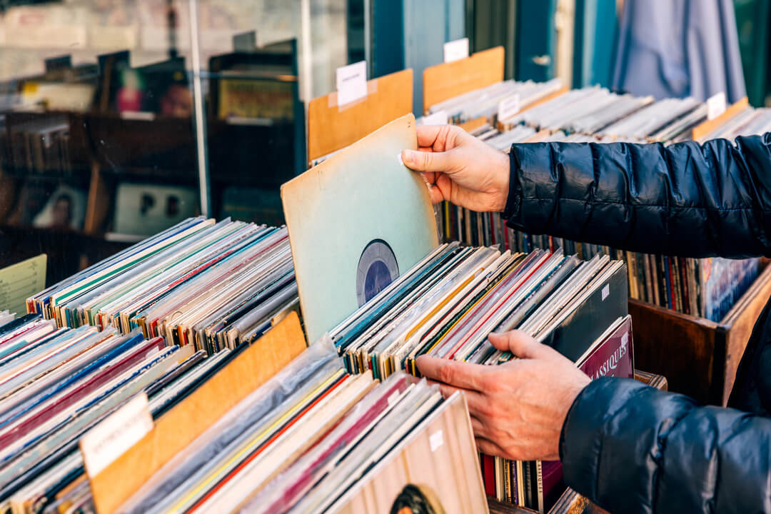 A person looking through a collection of vinyl records in a shop