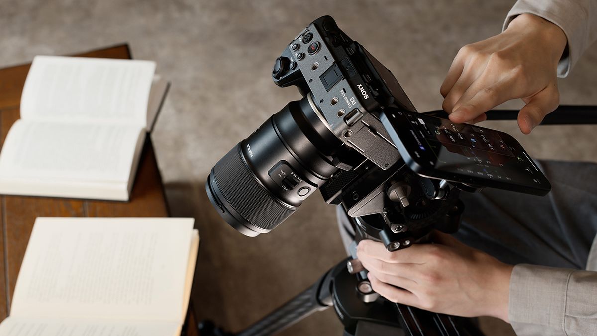 A photographer using the Tamron mobile app with the Tamron-Link