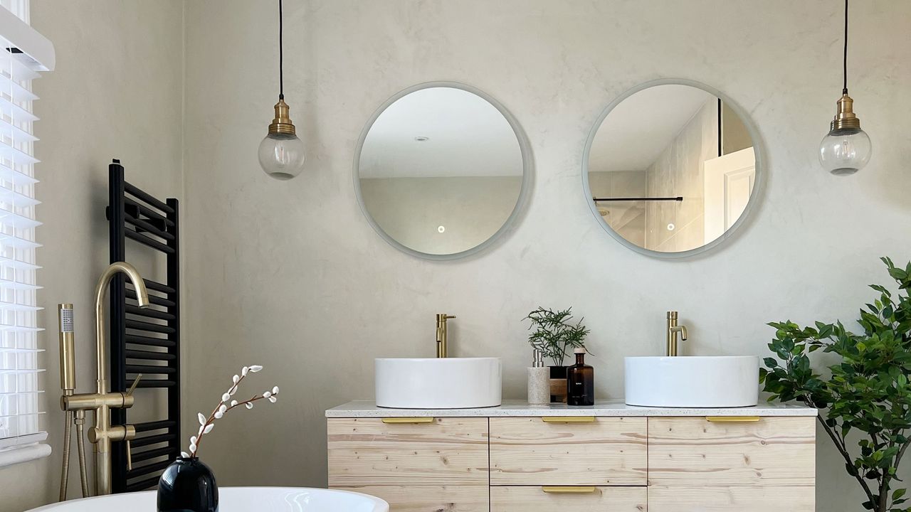 Japandi-style bathroom with circular mirrors, double sink and micro cement wall