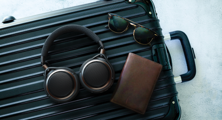 Audio-Technica headphones in muted lighting, worn by a man while gaming and also on a briefcase