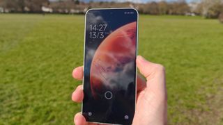 The Xiaomi 15 lock screen against a grassy field